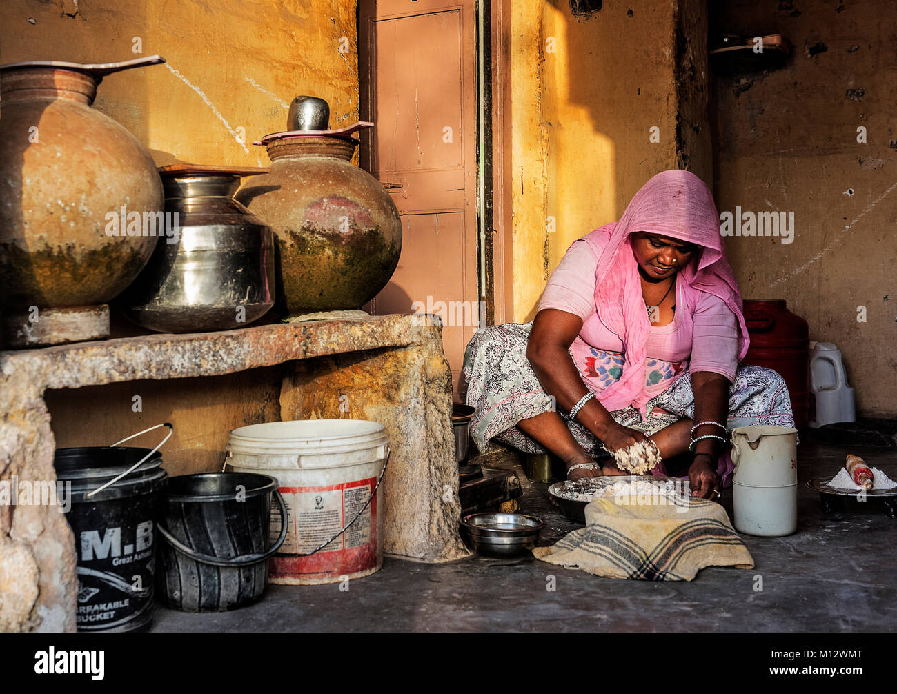 Donna di Rajasthani preparazione del cibo per la cena in casa sua, India Foto Stock