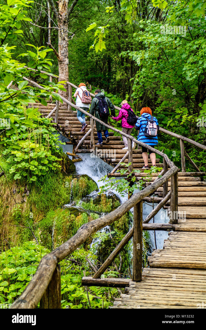 I turisti a piedi fino boardwalk passi al Parco Nazionale dei Laghi di Plitvice, Croazia Foto Stock