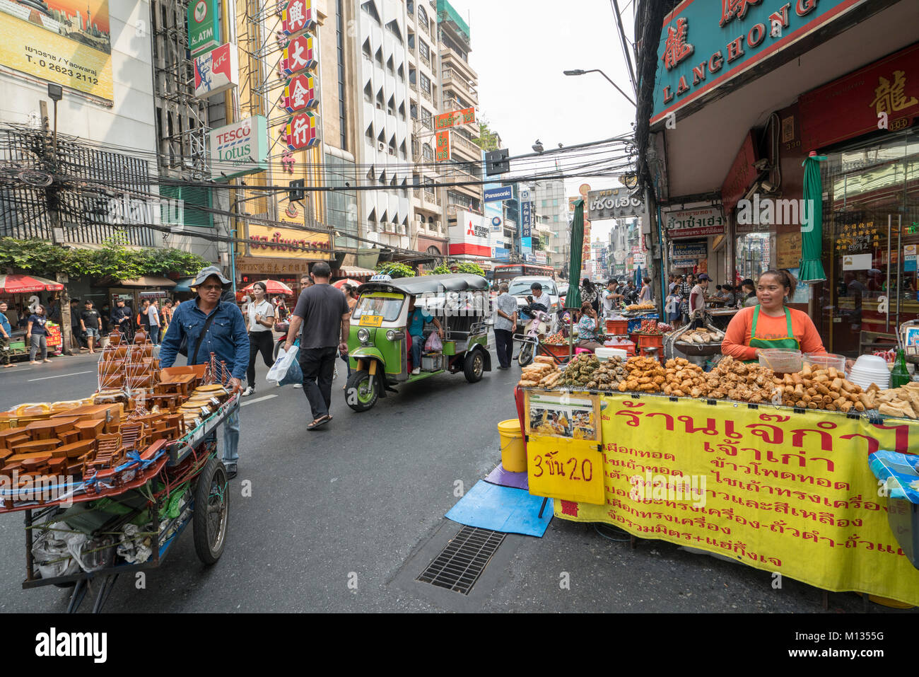 La gente tra le bancarelle di cibo di strada in Chinatown a Bangkok, in Thailandia Foto Stock