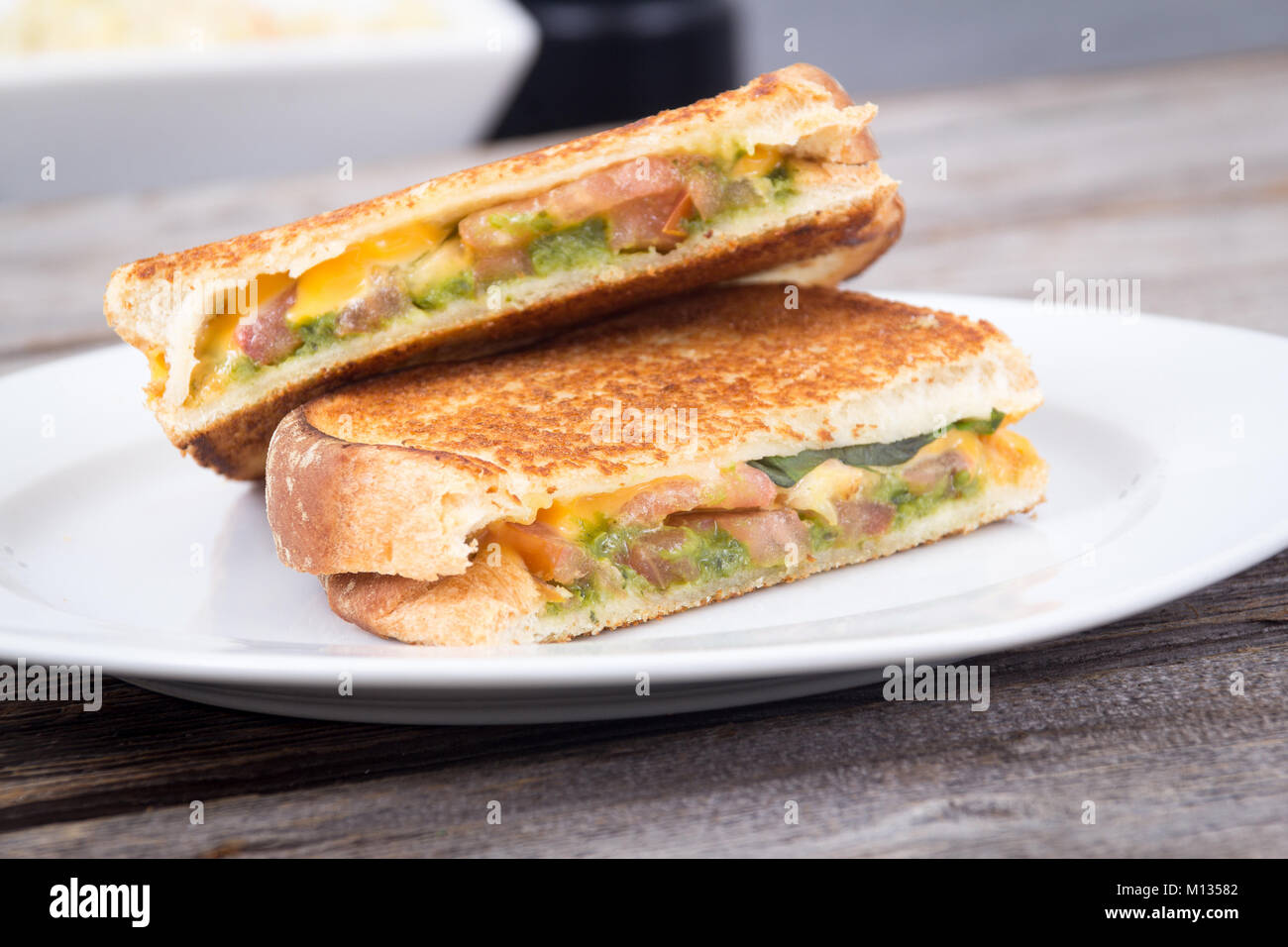 Pesto di pomodoro formaggio grigliato panino su tavola in legno rustico Foto Stock