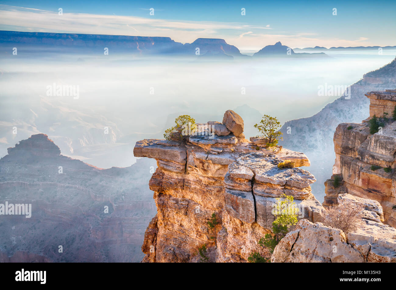 I raggi di luce solare attraverso la nebbia di mattina nel Grand Canyon, Arizona dal South Rim Foto Stock