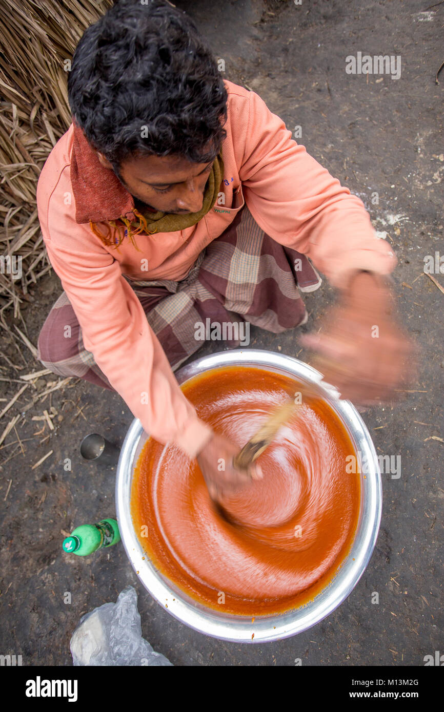 Colore dorato bollita CALDA Data Palm Tree melasso è di miscelazione a Iswardi, Bangladesh. Foto Stock