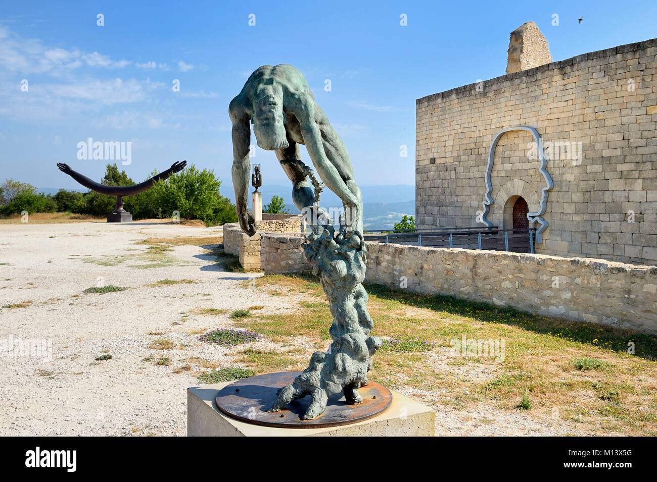 Francia, Vaucluse, Parc Naturel Regional du Luberon (Parco naturale regionale del Luberon), Lourmarin, etichettati Les Plus Beaux Villages de France (i più bei villaggi di Francia), Lacoste, Lacoste castello, una delle residenze del Marchese de Sade e oggi di proprietà di Pierre Cardin, scultura albero della vita dell'artista Ettore Greco in primo piano Foto Stock