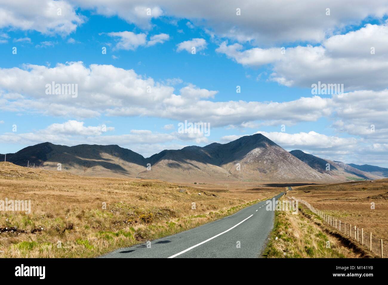 L'Irlanda, nella contea di Galway, Parco Nazionale del Connemara, Maumturk Road e montagne Foto Stock