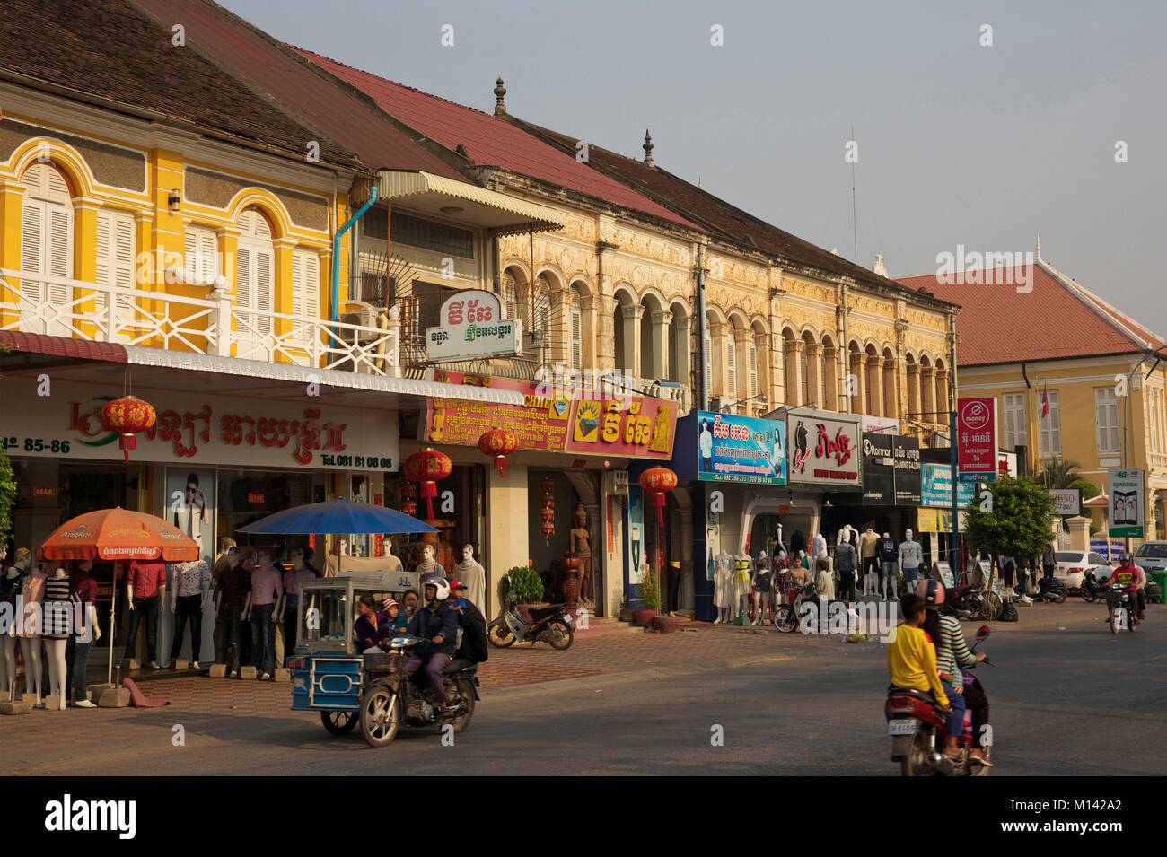 Cambogia, Battambang, scooter passando davanti al francese edifici coloniali Foto Stock