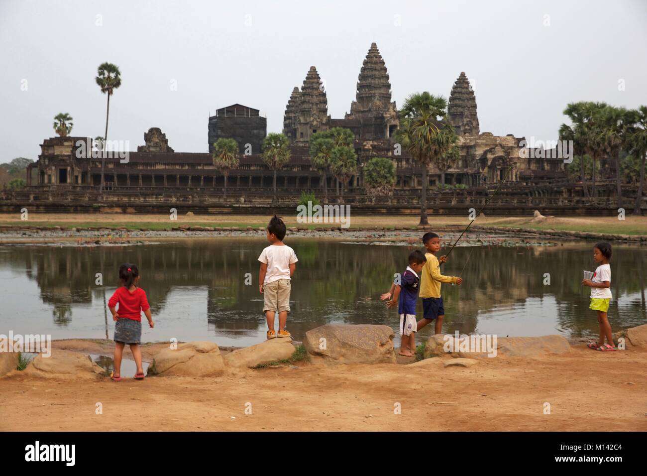 Cambogia Angkor, elencato come patrimonio mondiale dall' UNESCO, bambini playin davanti di Angkor Wat bacino, il più grande tempio della vecchia città Khmer di Angkor Thom Foto Stock