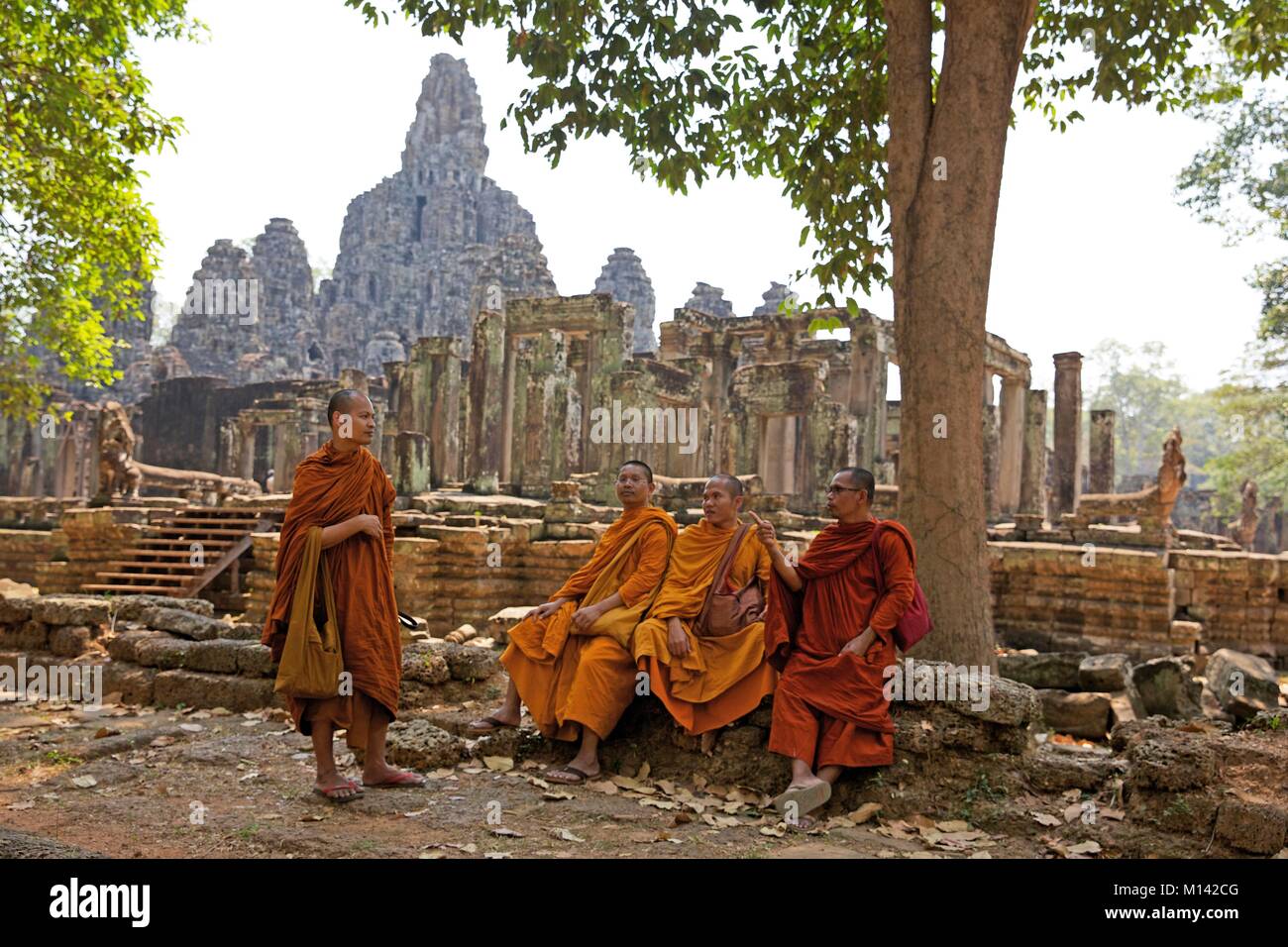 Cambogia Angkor, elencato come patrimonio mondiale dall UNESCO, buddists monaci vestiti in abiti dello zafferano a discutere di fronte al Bayon, il tempio principale della vecchia città Khmer di Angkor Thom Foto Stock