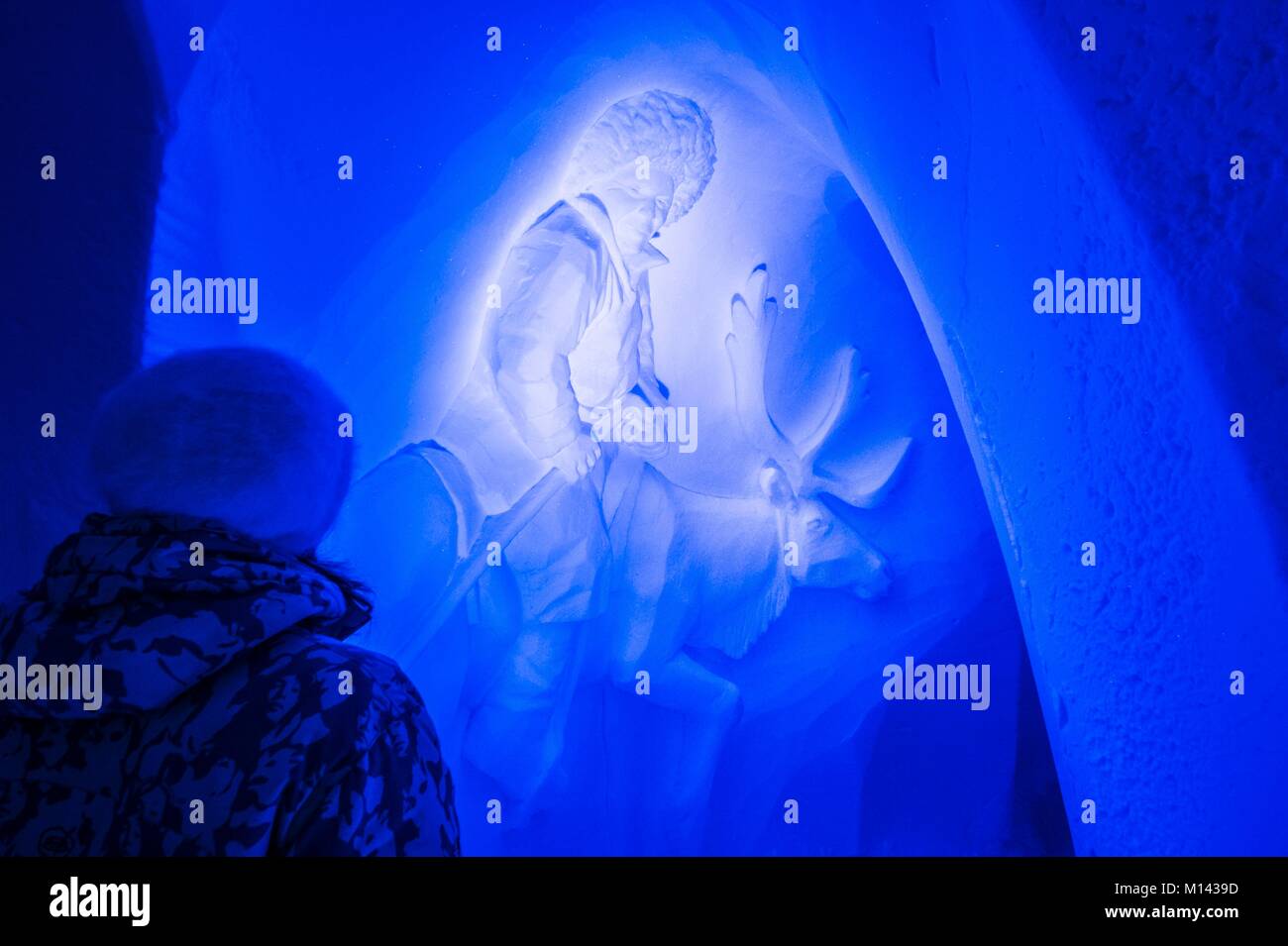 Francia, Savoie, Valle Tarentaise, il massiccio della Vanoise, archi 2000 ski resort, donna osservando il bassorilievo di un mongolo allevatore di renne nella neve della parete della galleria con sculture di igloo-village, durante la stagione invernale il 2017-2018 Foto Stock