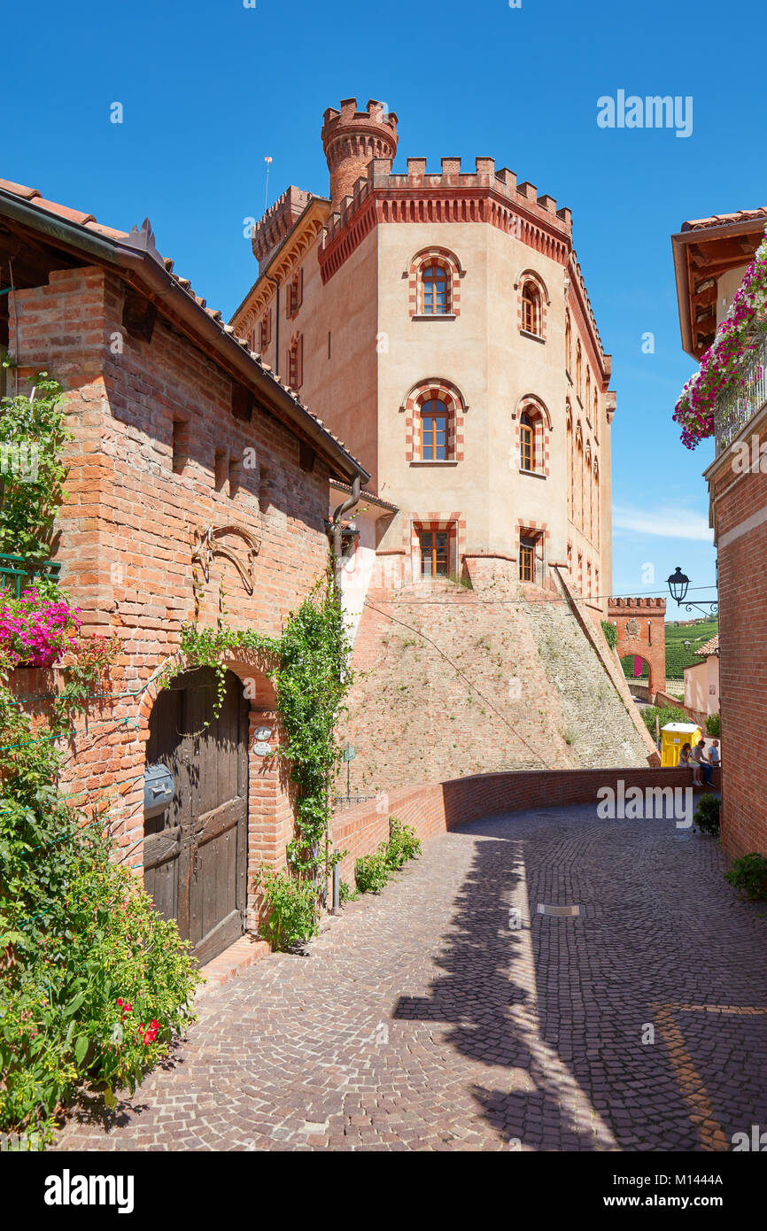 Il Barolo il castello medievale e la strada con piante verdi in una soleggiata giornata estiva, cielo blu in Barolo, Italia Foto Stock
