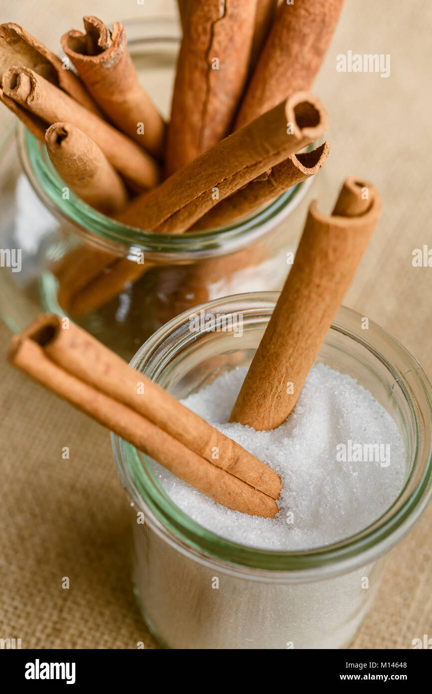 Ciotola di zucchero con bastoncini di cannella Foto Stock