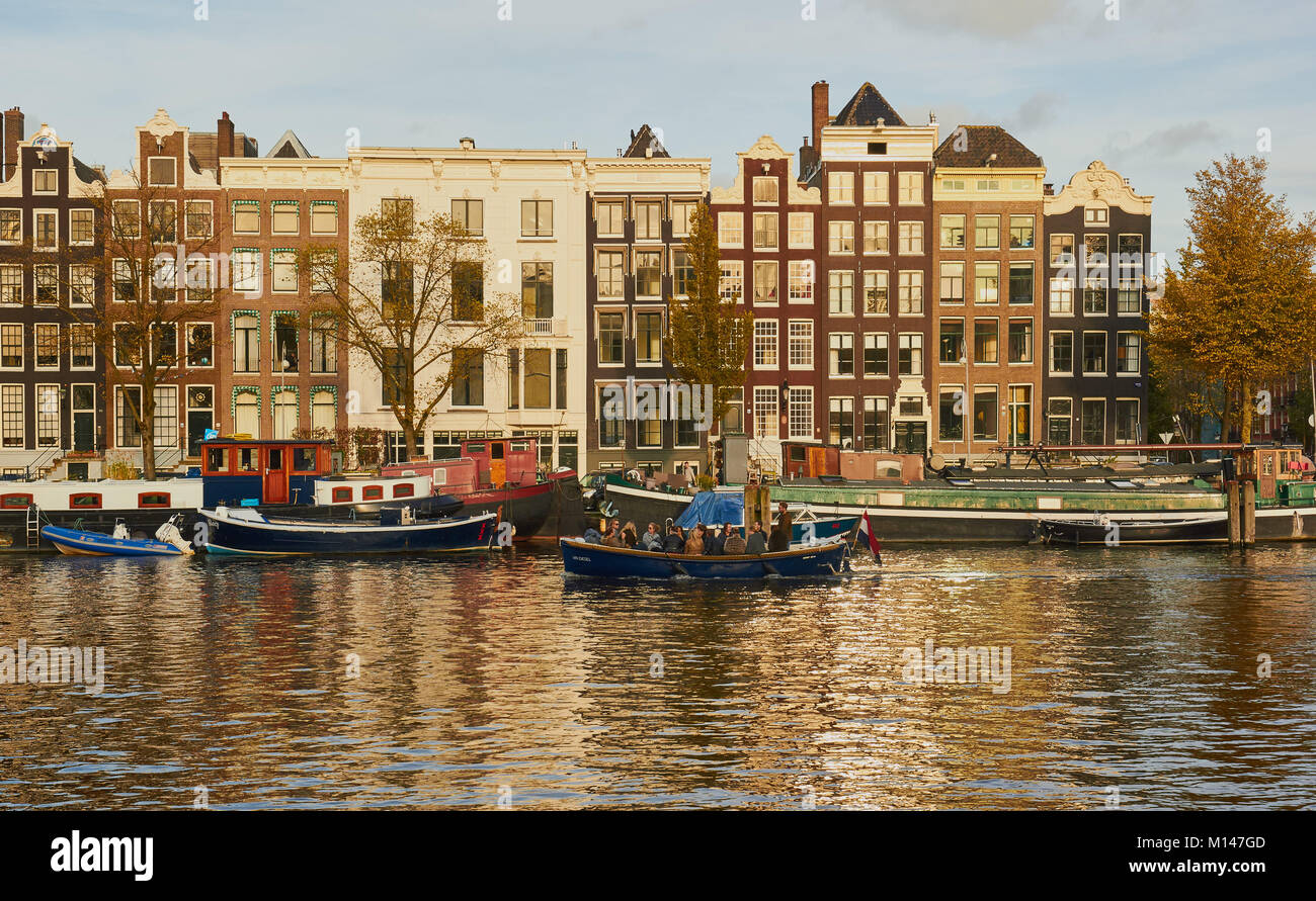 Tipica architettura olandese e barche e chiatte sul fiume Amstel di Amsterdam, Paesi Bassi Foto Stock