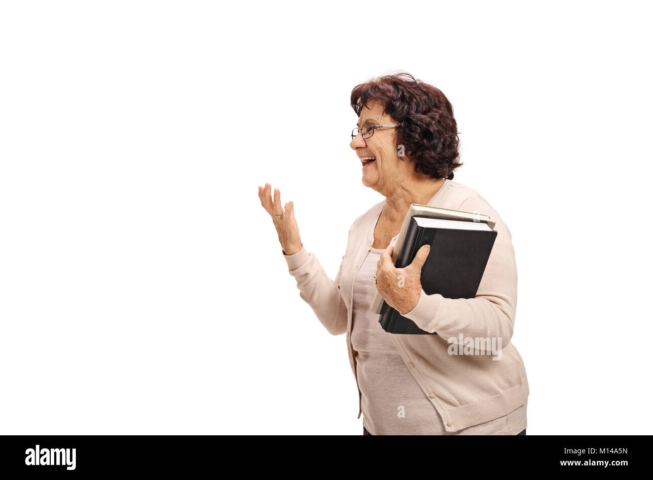 Donna anziana con libri parla con qualcuno isolato su sfondo bianco Foto Stock