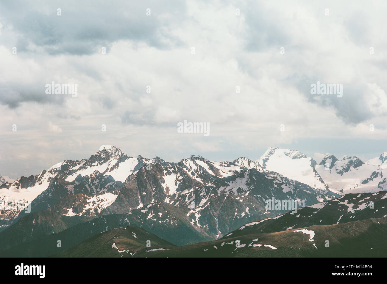 Rocciose montagne innevate vette e nuvole paesaggio viaggio estivo natura selvaggia scenic vista aerea Foto Stock