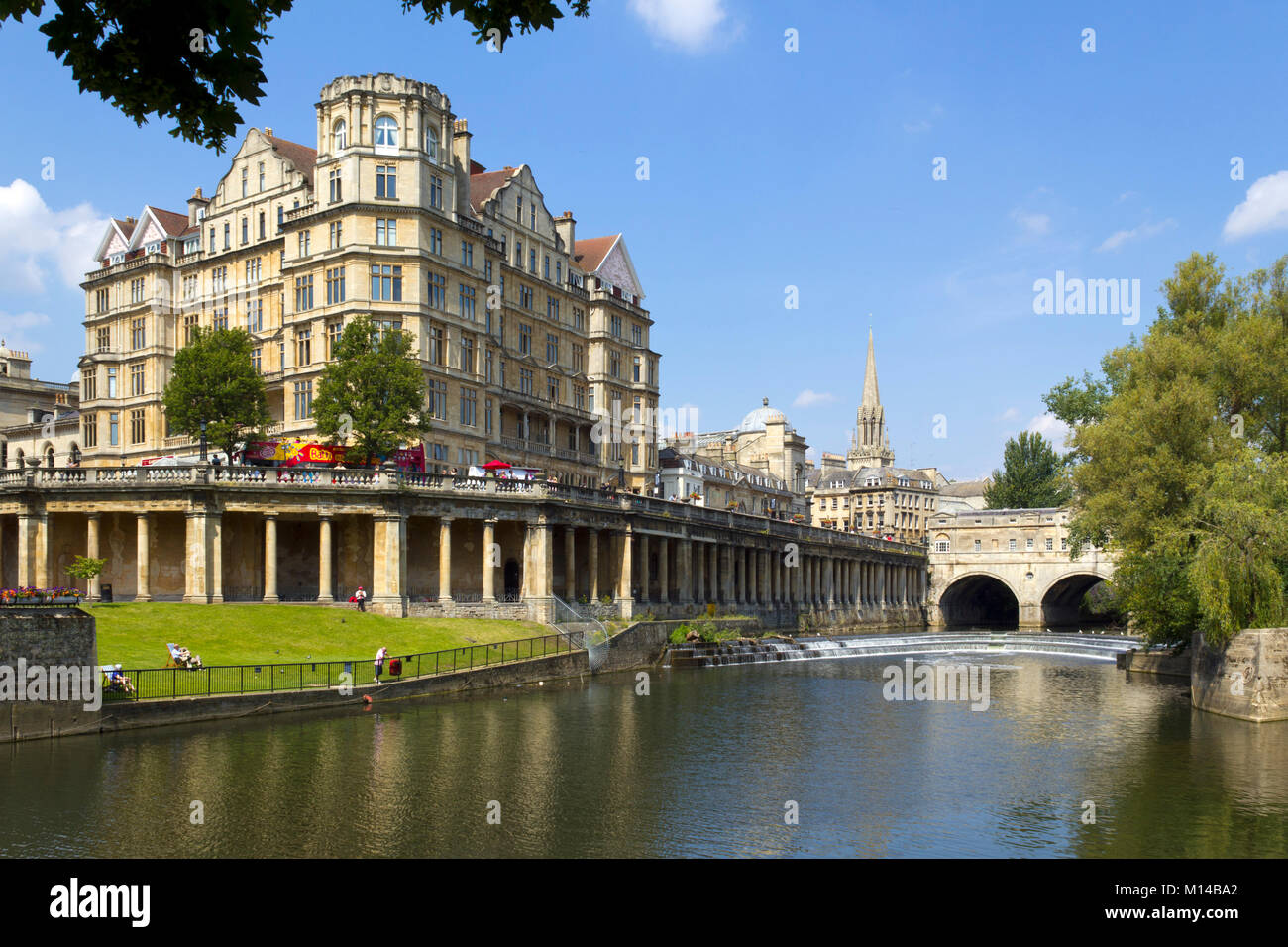 Bath, Regno Unito - 3rd luglio 2011: Turisti vicino al fiume Avon al sole estivo nella città di Bath, Somerset, Regno Unito. Bath è un sito patrimonio dell'umanità dell'UNESCO famoso per la sua architettura. Foto Stock