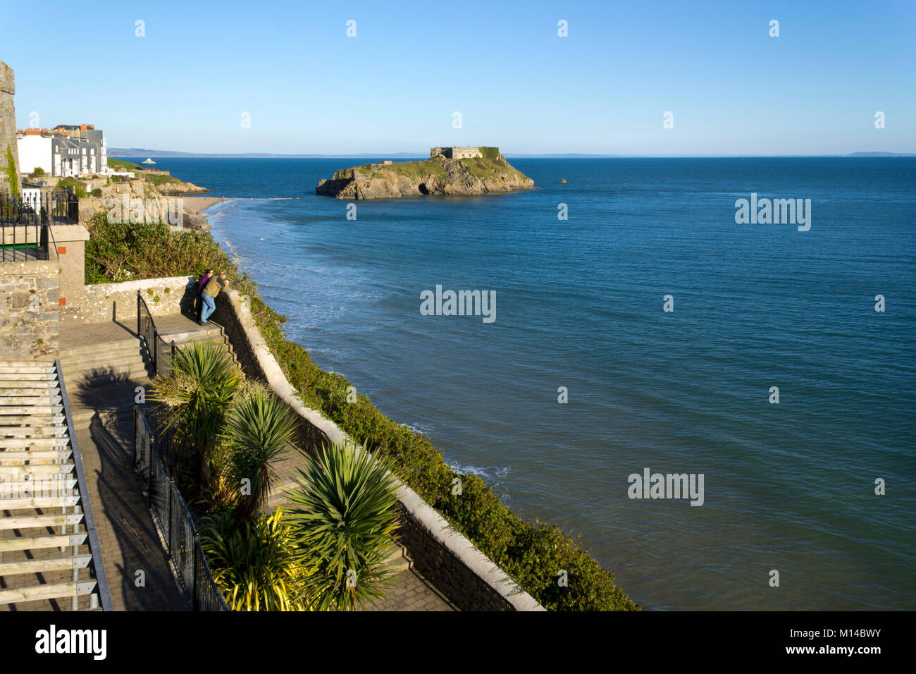 Tenby, Regno Unito - 6th novembre 2011: Una coppia gode la vista dai giardini della scogliera sotto il sole d'inverno, Tenby, Pembrokeshire, Galles, Regno Unito. Tenby sperimenta un clima marittimo con estati fresche e inverni miti ed è uno dei luoghi più soleggiato del Galles. Foto Stock