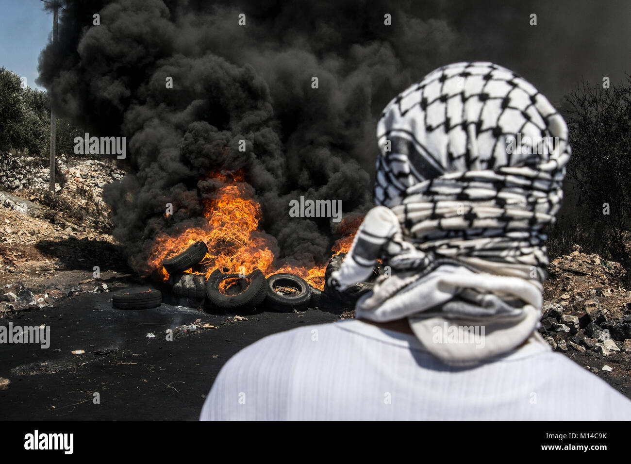 Conflitto israelo-palestinese. Dimostranti palestinesi bruciando pneumatici durante scontri con l esercito israeliano presso il Kafr Qaddum dimostrazione - Palestina Foto Stock