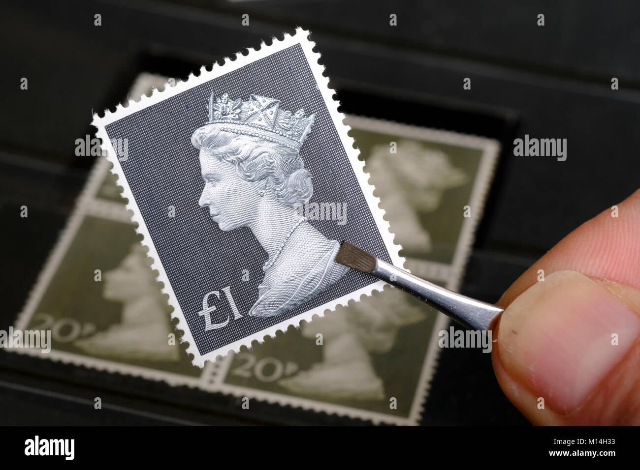 Vintage £1 timbro essendo trattenuto dal collettore di timbro Foto Stock