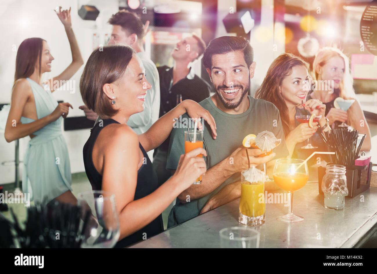 Coppia giovane stanno bevendo cocktail e divertirsi in discoteca Foto Stock