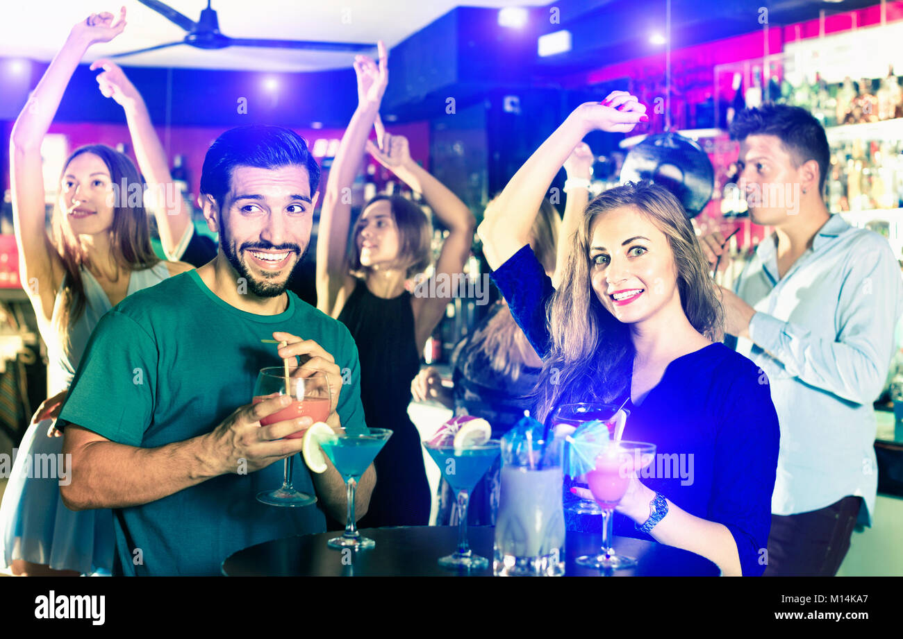 Felice l'uomo con la donna stanno bevendo un cocktail sulla corporate partito. Foto Stock