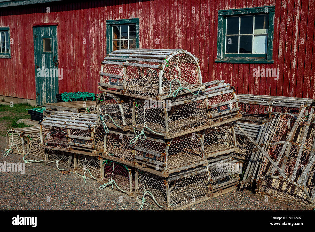 Trappole di astice di fronte a un vecchio capannone rosso. Foto Stock