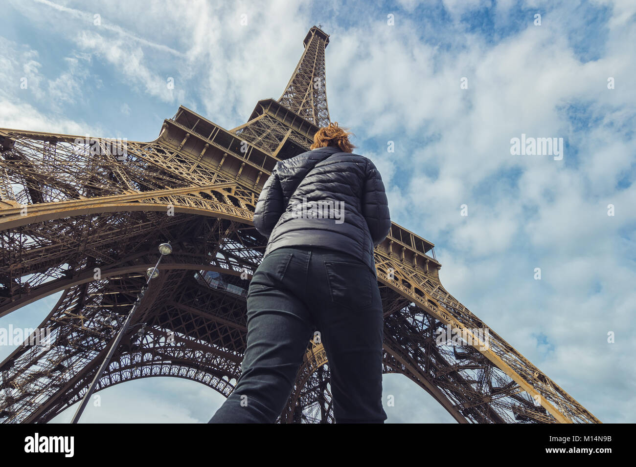 La donna va sotto la Torre Eiffel a Parigi. Foto Stock