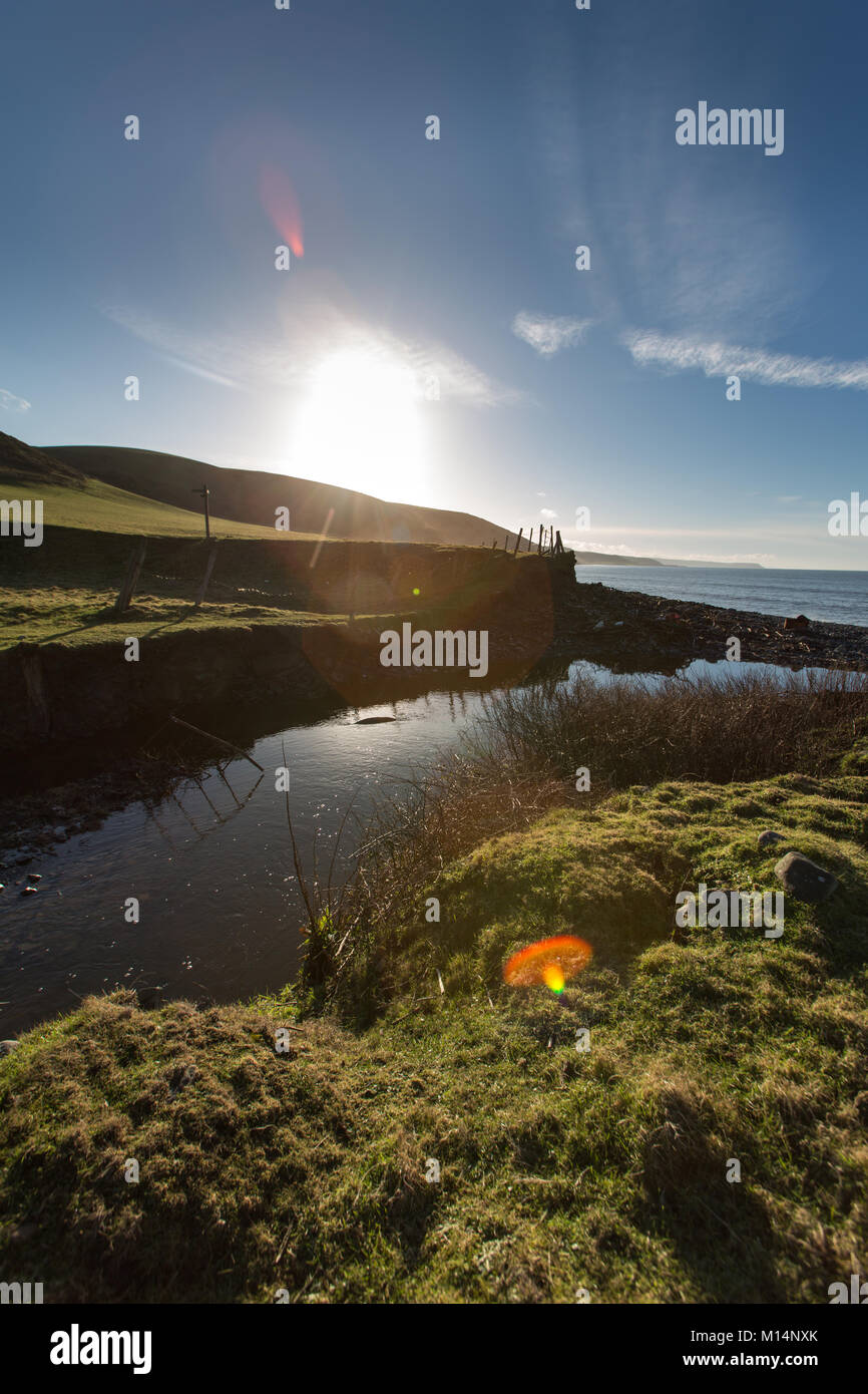 Il Wales coast Path. Una corrente attraversa il Galles e Ceredigion costa itinerario percorso, tra i villaggi di Llanon Aberarth e. Foto Stock