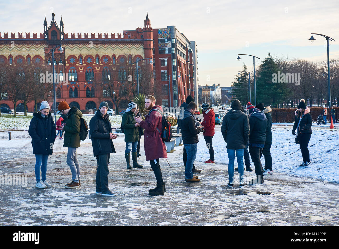 I giovani si sono riuniti di fronte al Palazzo del Popolo a Glasgow per giocare online giochi gps sui loro telefoni cellulari. Foto Stock