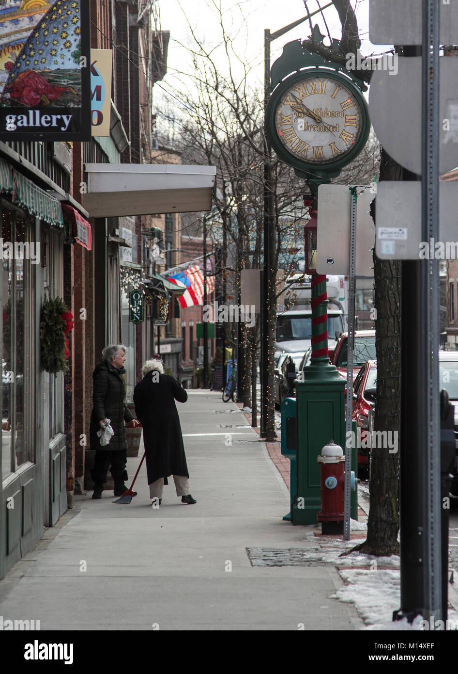 Una donna di pulizia nella parte anteriore del suo negozio a Brattleboro, Vermont Foto Stock