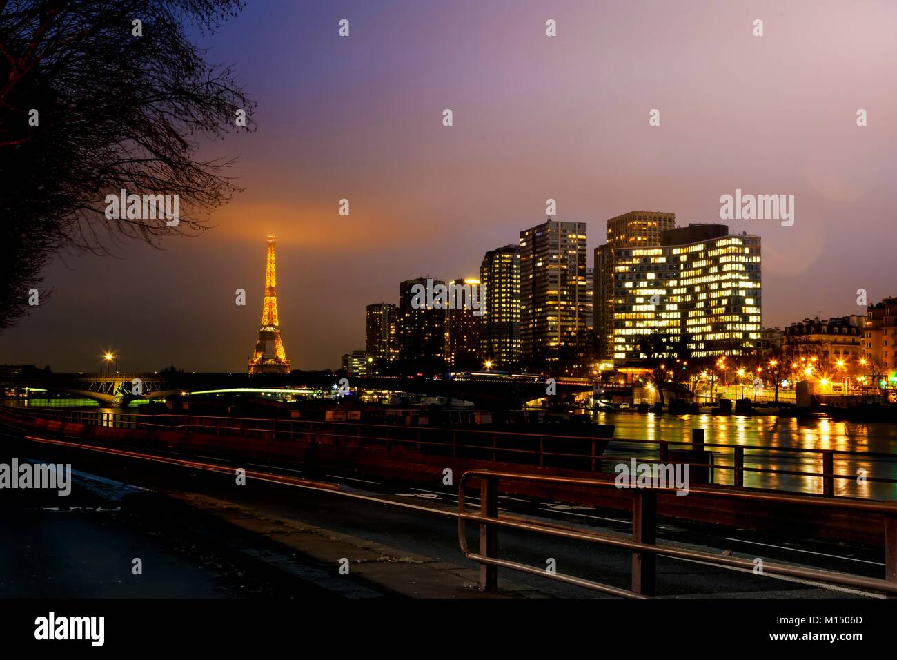 Vista panoramica del centro di Parigi di notte con riflessi sul Fiume Senna e illuminata la Torre Eiffel a distanza Foto Stock