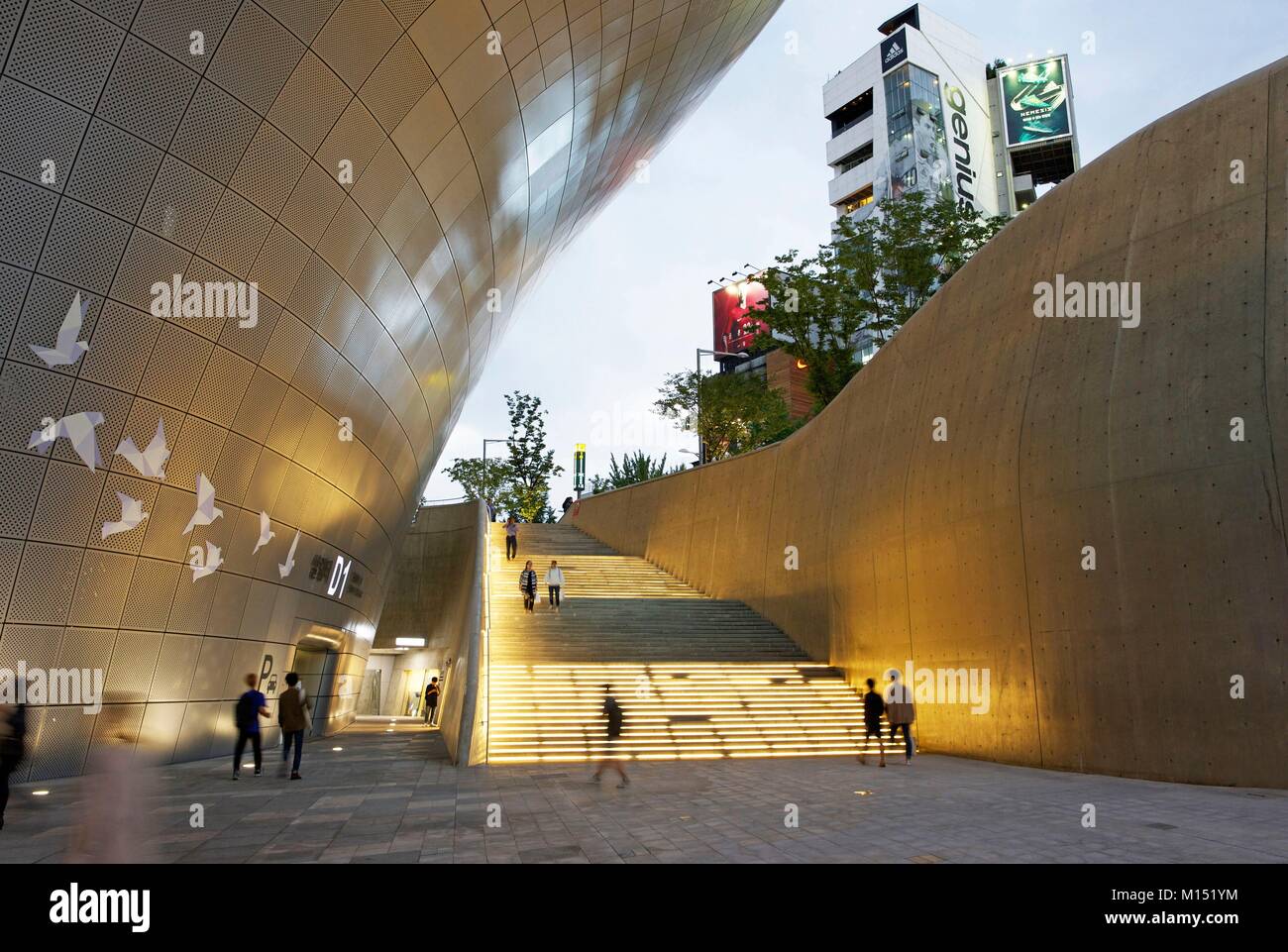 Corea del Sud, Seoul, persone che camminano in mezzo al design di Dongdaemun Plaza, edificio futuristico dell'architetto Zaha Hadid Foto Stock