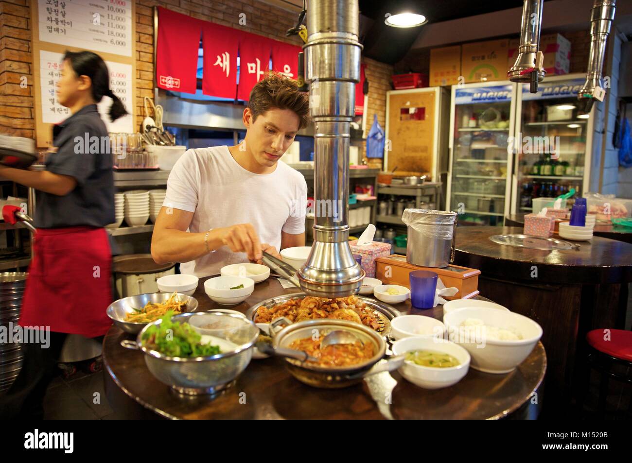 Corea del Sud, Seoul, Fabien Yoon, stella francese della media coreani, preparare un barbecue coreano in un ristorante barbecue Foto Stock