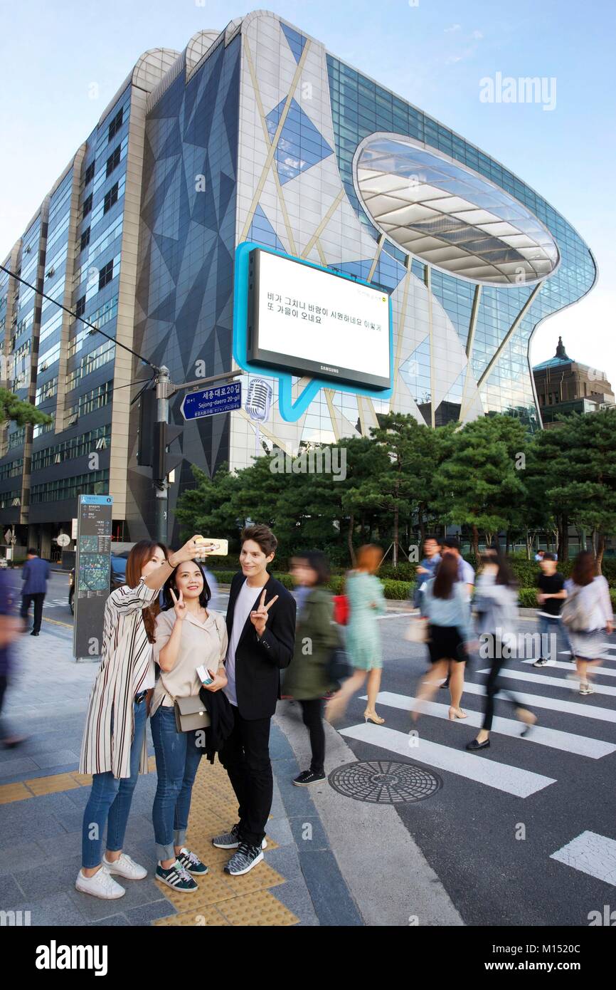 Corea del Sud, Seoul, Fabien Yoon, stella francese della media coreani, la condivisione di un selfie con ventole, di fronte al municipio edificio di design Foto Stock