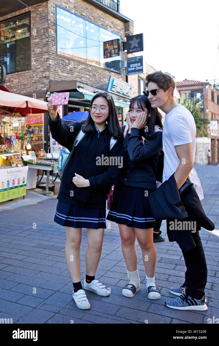 Corea del Sud, Seoul, Fabien Yoon, stella francese della media coreani, la condivisione di un selfie con ventole in una strada pedonale di Samcheong dong Foto Stock