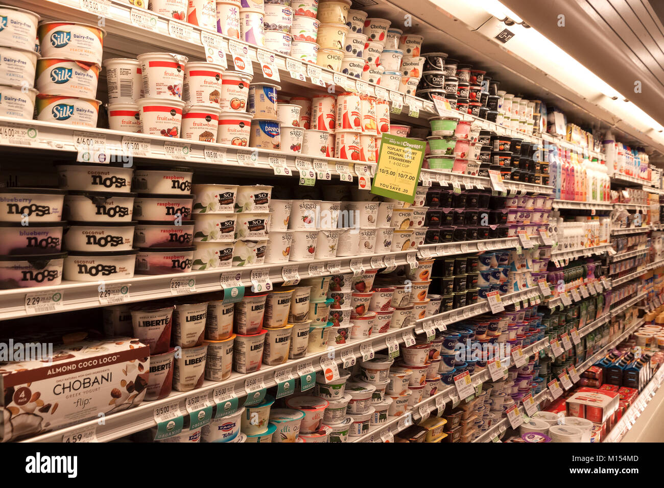 Varietà di yogurt su scaffali in un supermercato. Foto Stock
