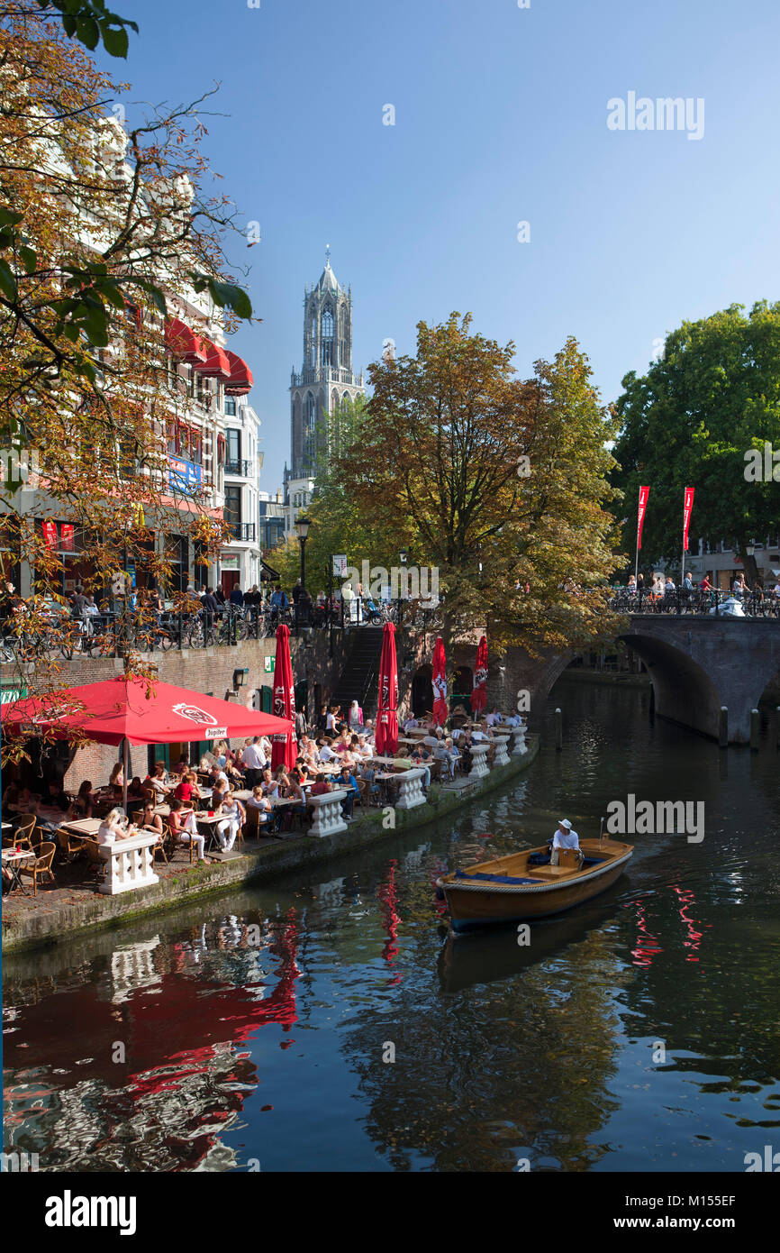 I Paesi Bassi Utrecht, caffè all'aperto al canale chiamato Oude Gracht. Sullo sfondo la torre del Duomo, la torre campanaria più alta nei Paesi Bassi. Foto Stock