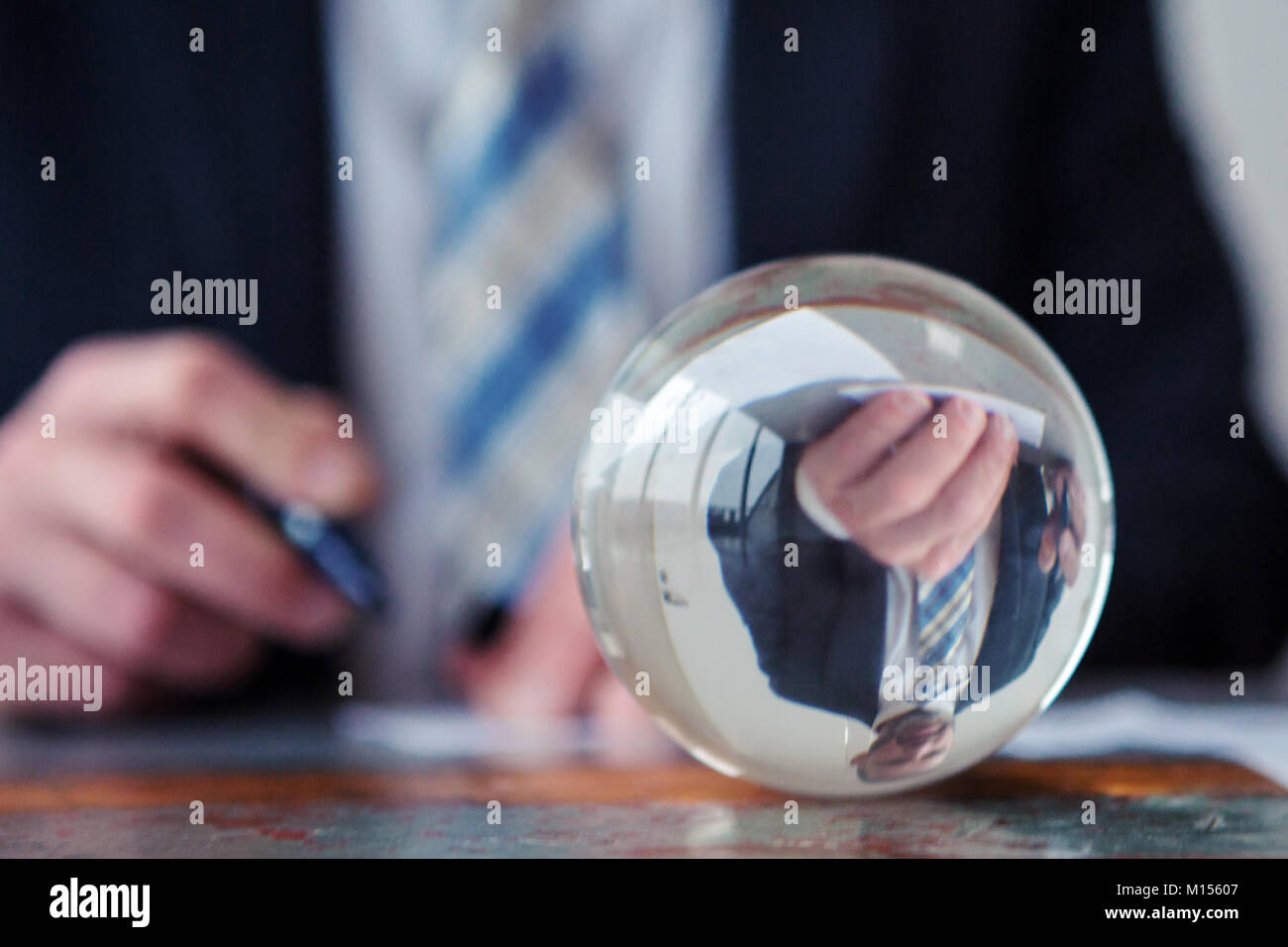 Primo piano di imprenditore firma carte nella parte anteriore della sfera di vetro Foto Stock
