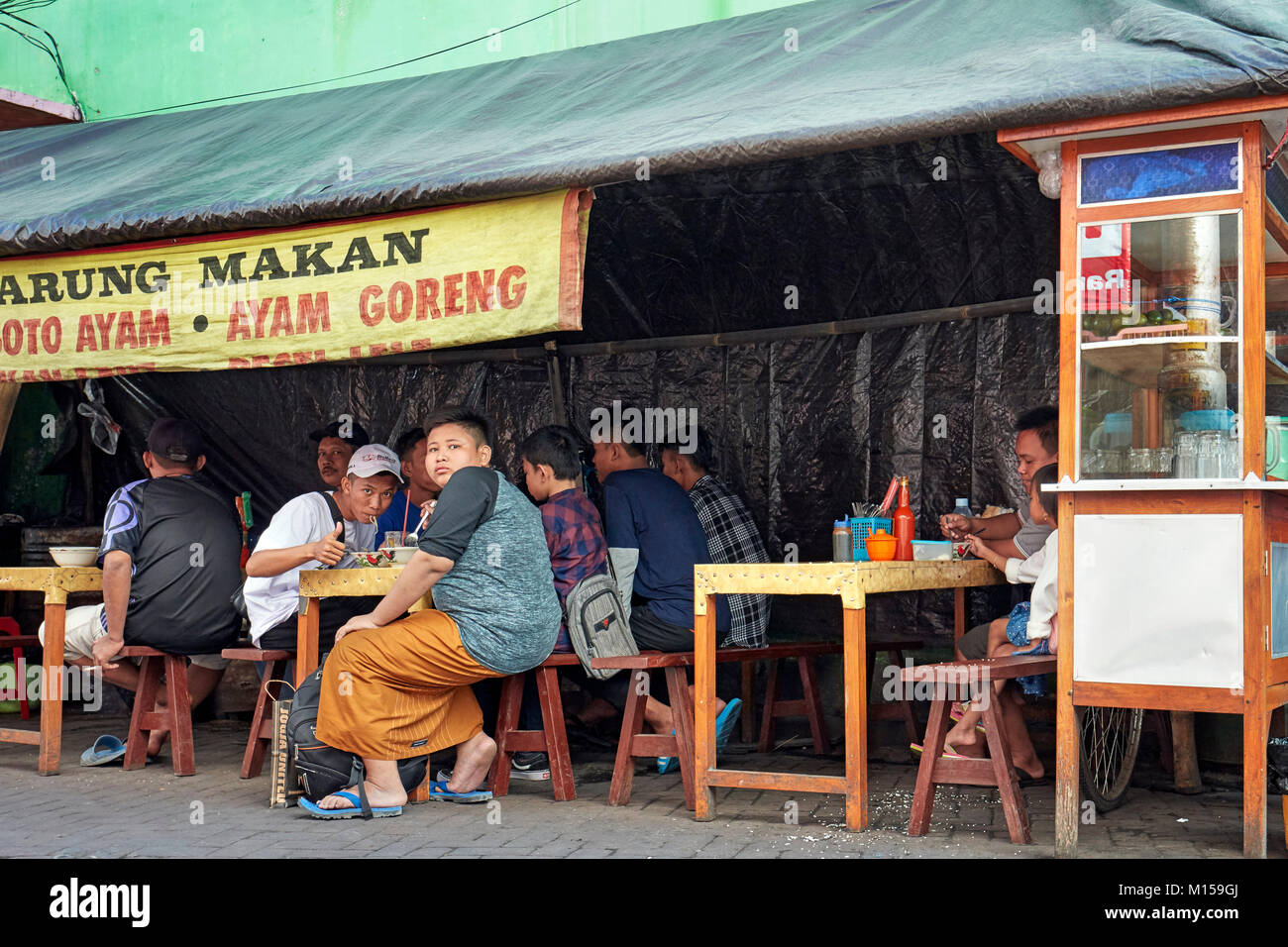 Persone di mangiare in un piccolo ristorante di strada su Ketandan Wetan street. Yogyakarta, Java, Indonesia. Foto Stock