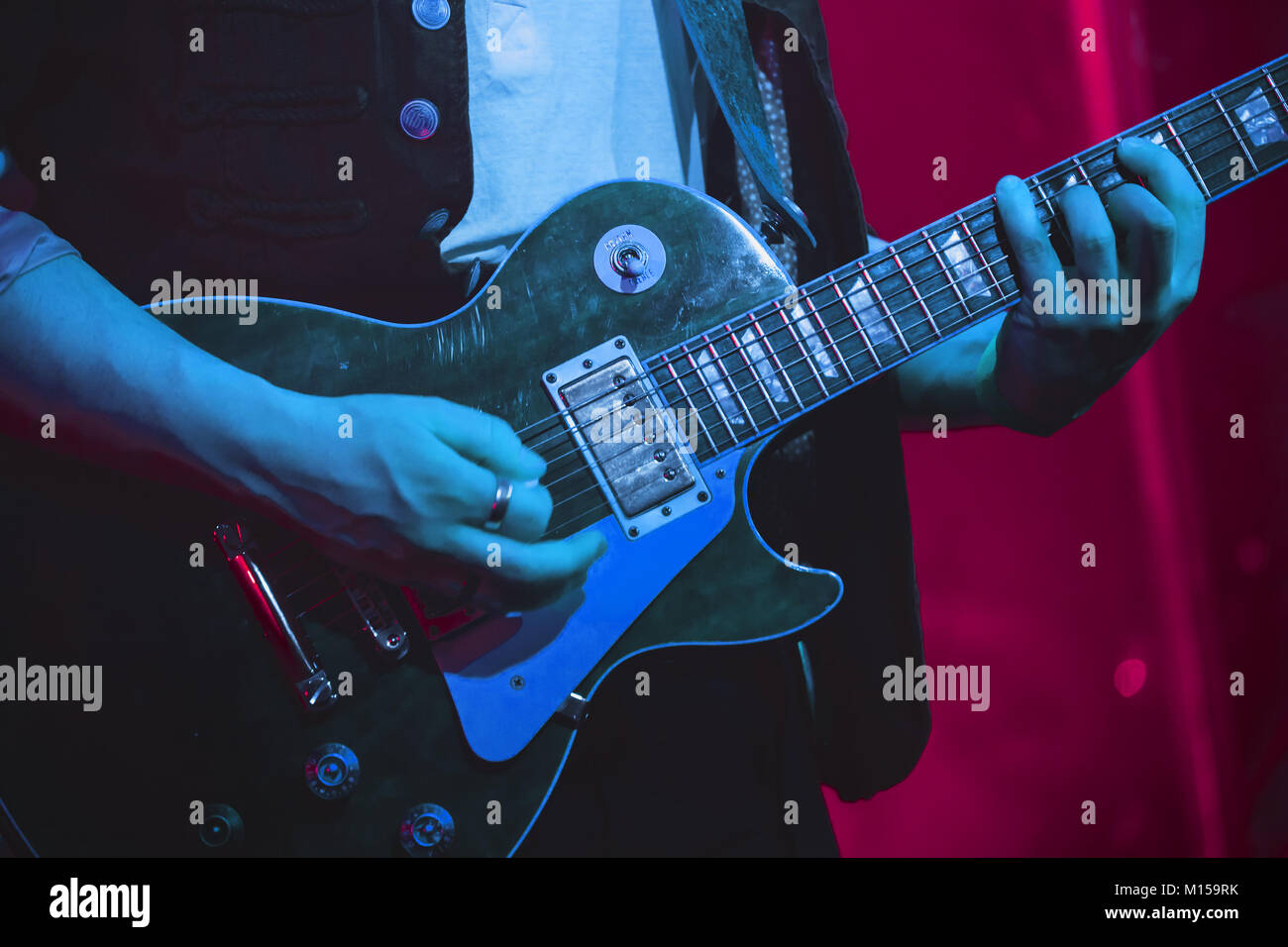 Il chitarrista suona la chitarra elettrica su un palco, foto con morbida messa a fuoco selettiva Foto Stock