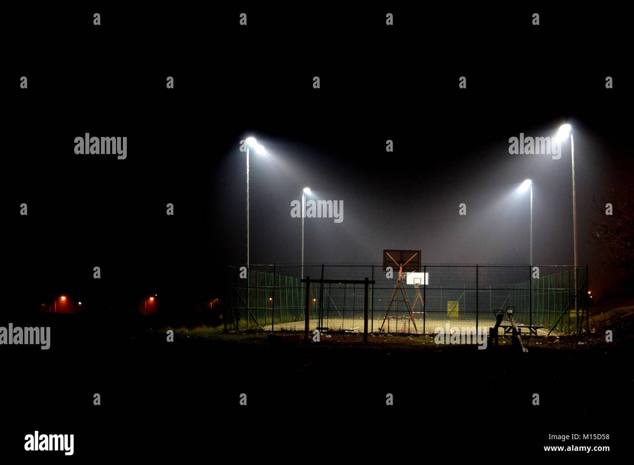 Campo da pallacanestro illuminata di notte Foto Stock