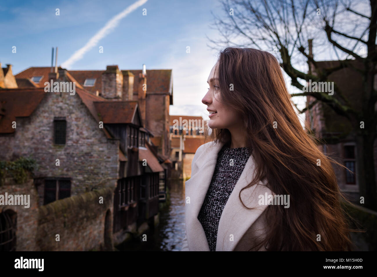 Giovane donna di stare in un posto romantico nel centro storico di Brugge, in Belgio. Turista femminile è ispirata da atmosfera della città Foto Stock