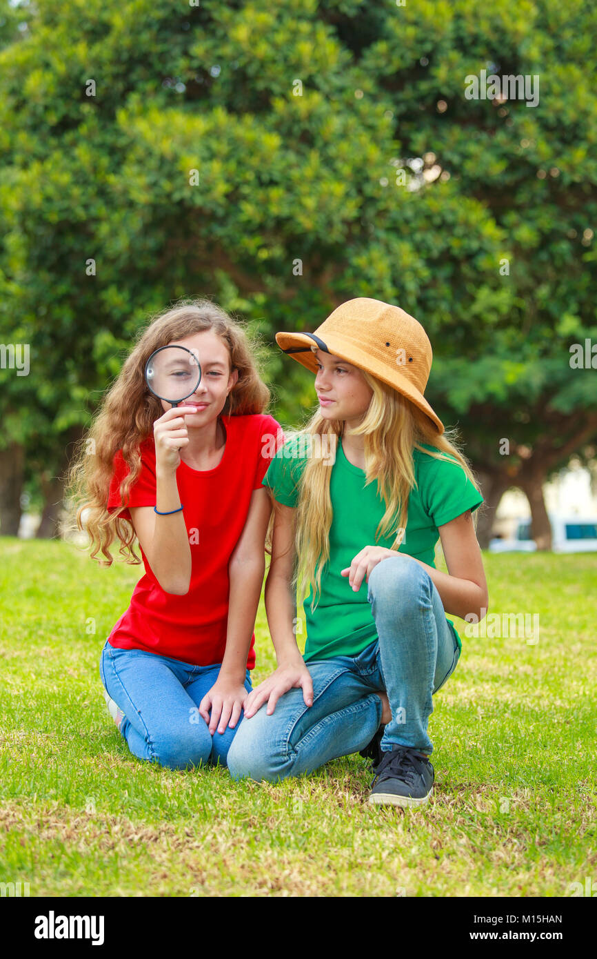 Due ragazze della scuola di esplorare la natura con lente di ingrandimento Foto Stock