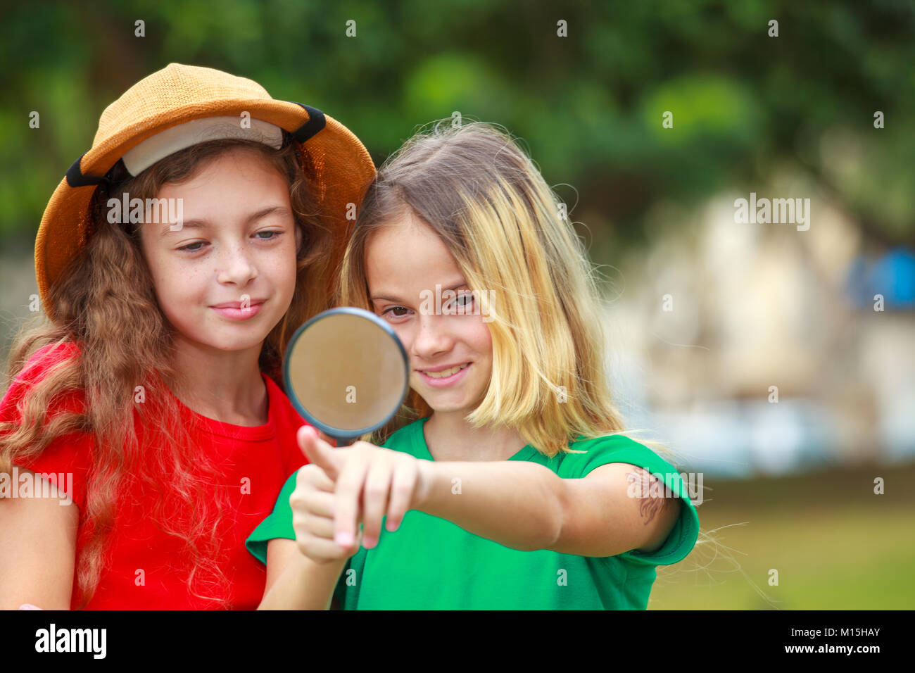 Due ragazze della scuola di esplorare la natura con lente di ingrandimento Foto Stock