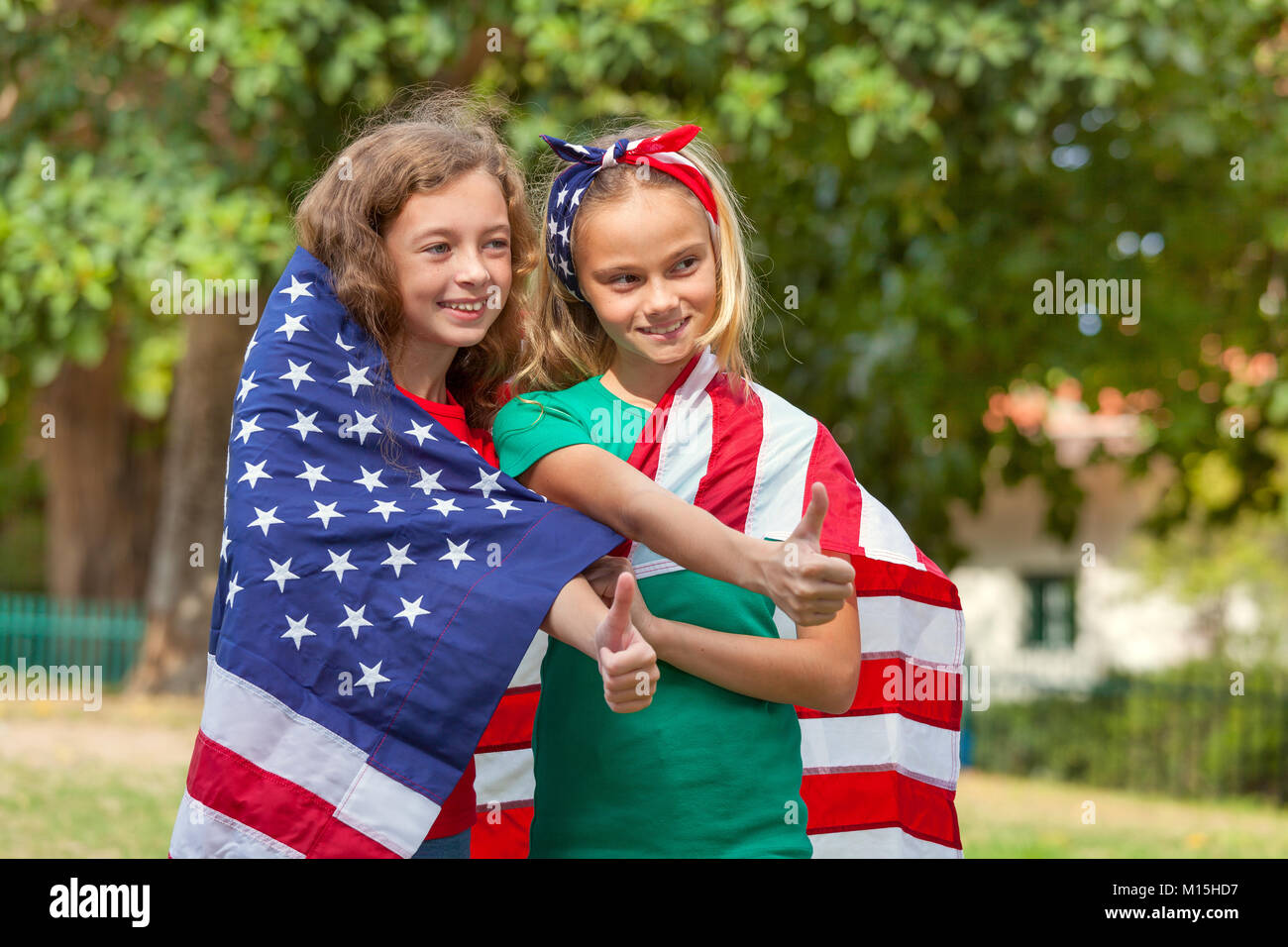 Due ragazze avvolto in una bandiera statunitense Foto Stock