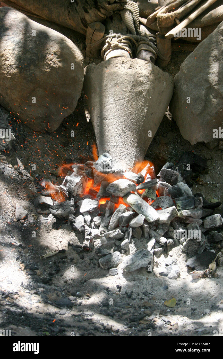 Uomo Datoga prepara e illumina il falò utilizzando una pelle di capra a soffietto. Fotografato in Africa, Tanzania, Lago Eyasi Foto Stock