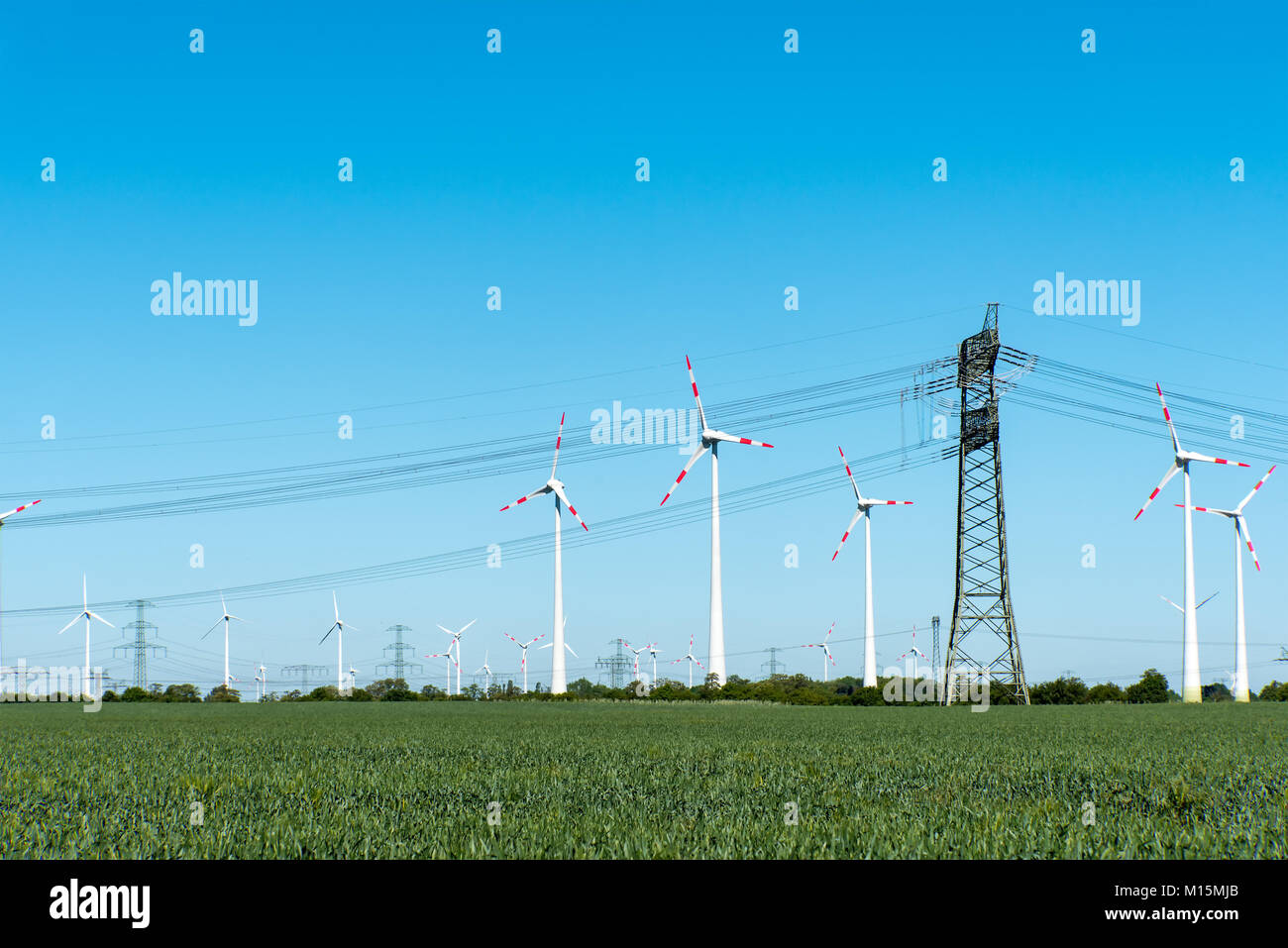 Impianti di energia eolica e linee di trasmissione di potenza visto in Germania rurale Foto Stock