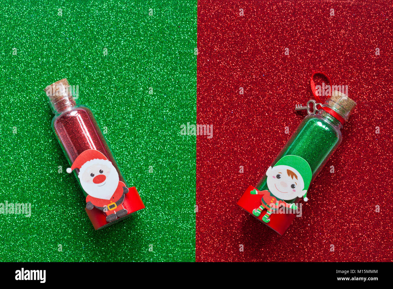 Tubo pot vasetto di Natale glitter - rosso con Babbo Natale Santa su & verde con Elf su - il rosso e il verde glitter foglio espanso sfondo texture Foto Stock