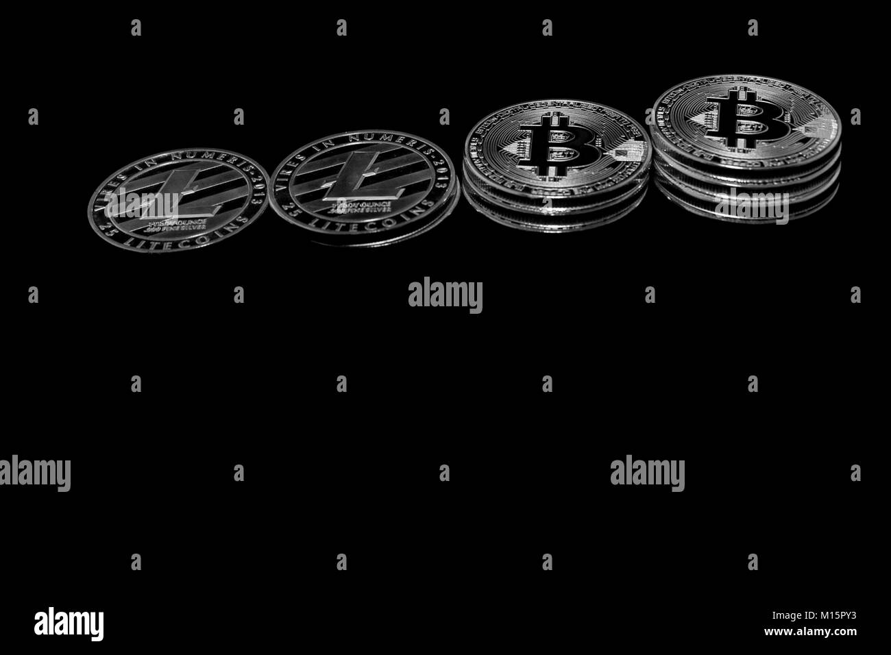 Su uno sfondo nero con testo libero lo spazio sono monete d'argento di un digital crypto valute - Litecoin Bitcoin e. Foto Stock