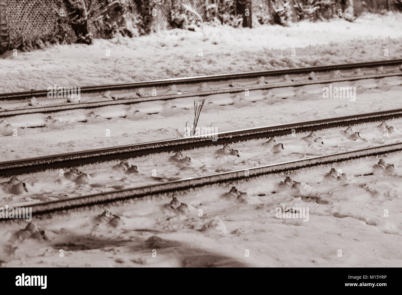 Linee ferroviarie nella notte nevosa con luci speciali e lambency. Foto Stock