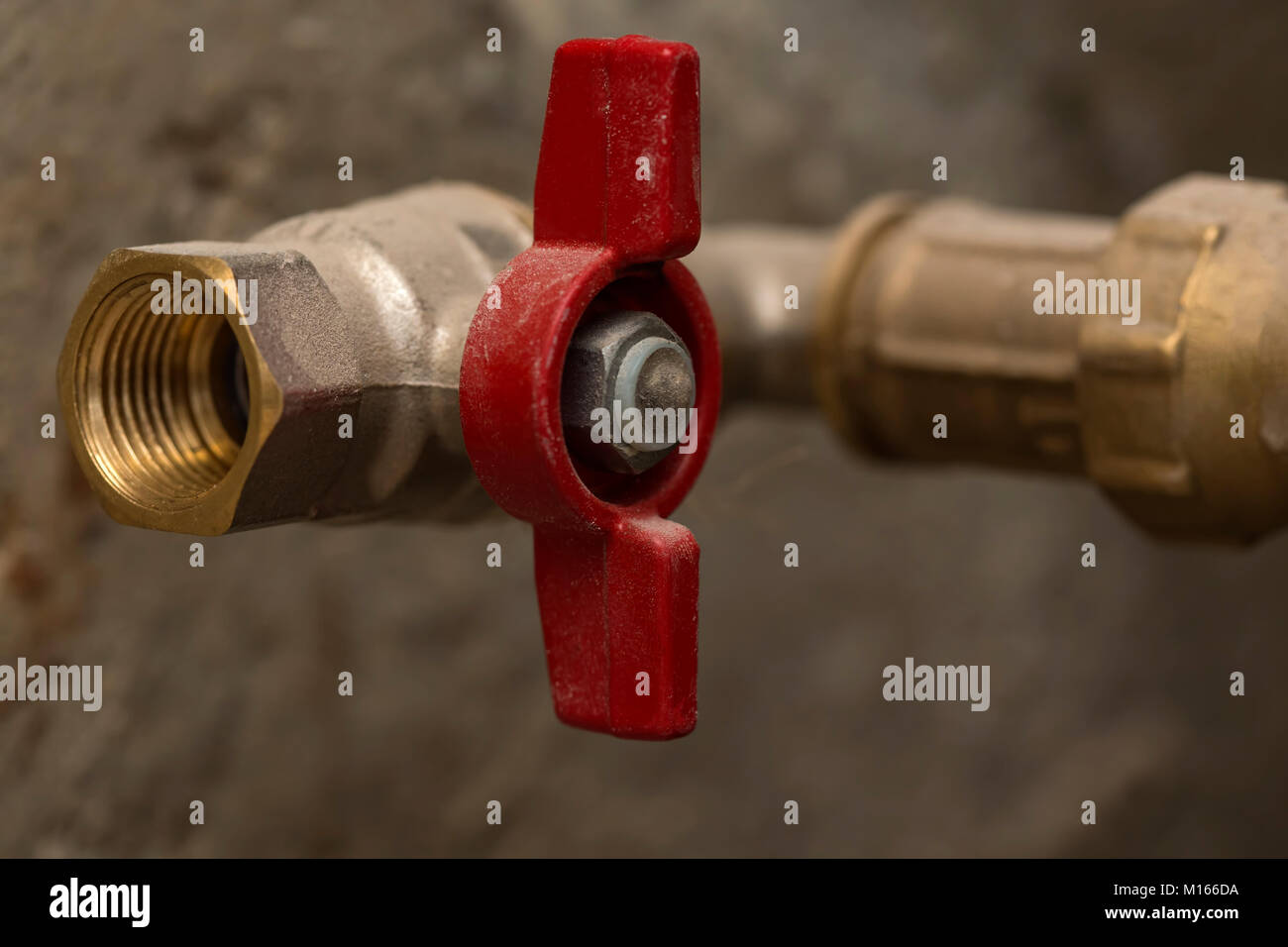 Close up rosso chiuso della valvola a sfera ottone sul tubo Foto Stock