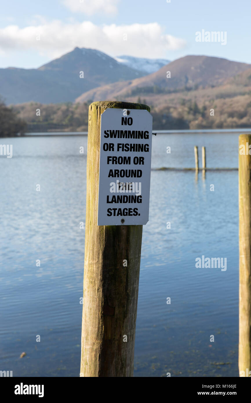 Un No nuoto/Pesca segno di avvertimento sulla Derwent Water pontili Near Keswick in inglese il Parco Nazionale del Distretto dei Laghi Foto Stock
